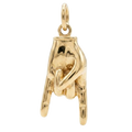 Gold pendant shaped like a hand on a white background